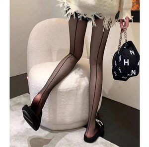 Detail of sheer black tights featuring a distinct back seam line for a slimming leg effect