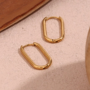 Macro detail of minimalist oval hoop earrings with polished 18K gold plated finish