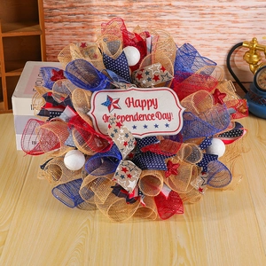 Independence Day wreath with red blue mesh and Happy Independence Day sign on wood