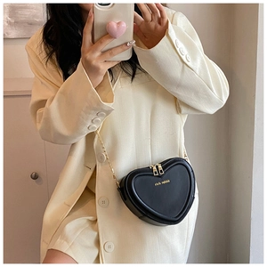 Detail einer schwarzen herzförmigen Umhängetasche mit goldener Kette und rich rabbit Logo