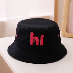 Gros plan d'un bob en coton noir avec motif 'hi' rose et graffitis de visage souriant
