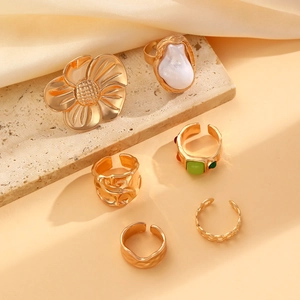 Detail of 6-piece vintage gold ring set with baroque pearl and floral relief motifs