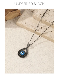 Macro shot of evil eye water drop pendant in gunmetal finish with dark stones