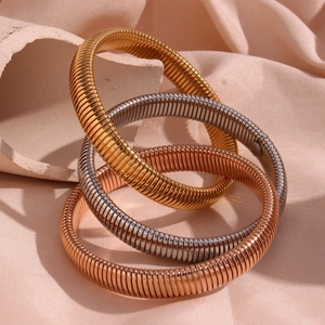 Macro detail of three-tone gold silver and rose gold flexible coil spring bracelets