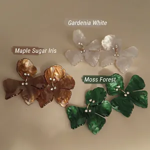 Floral resin earrings with crystal centers in white, amber brown, and dark green colors