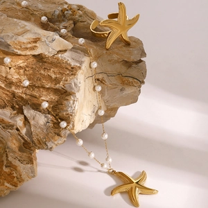 Détail d'un ensemble collier et bague étoile de mer dorée sur pierre naturelle