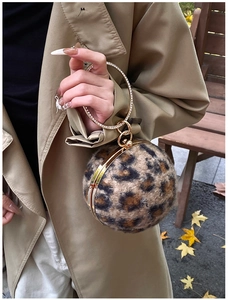 Close-up of leopard print plush round bag with rhinestone-inlaid golden ring handle