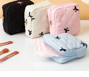 Detailed view of quilted sanitary pad bags in four colors with bow embroidery