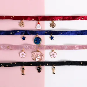 Flat lay of velvet pet collars with gold star patterns and festive holiday pendants