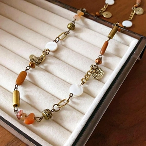 Detailed close-up of vintage floral ceramic beaded necklace in jewelry display box