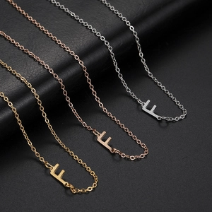 Three minimalist stainless steel initial F pendant necklaces in gold, rose gold and silver
