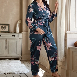 Women's dark navy floral satin pajama set with long sleeves and pants in a cozy room