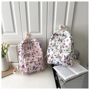 Dettaglio di zaini scolastici rosa e bianchi con motivi di fiori farfalle e tulipani