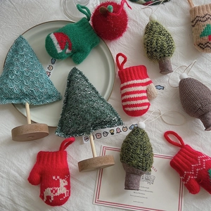 Handmade knitted Christmas tree ornaments with festive gloves and red plush apples