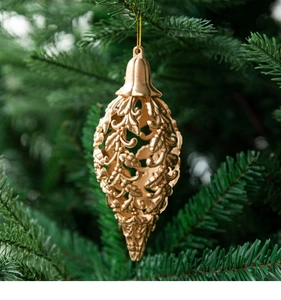 Close-up of golden teardrop hollow ornament hanging on a Christmas tree branch
