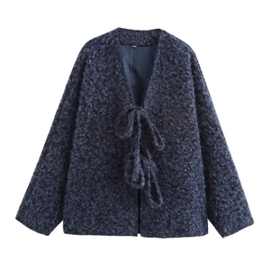 Close-up of fuzzy navy blue cardigan showing the tie-front closure and plush fabric texture