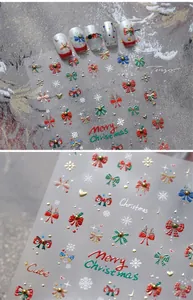 Detail of Christmas nail stickers with red bows, white snowflakes and golden stars