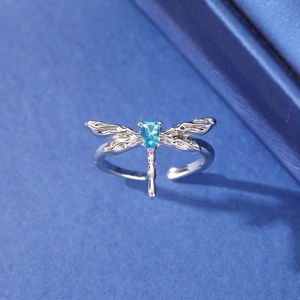 Detailed macro shot of an adjustable dragonfly ring with a blue teardrop stone