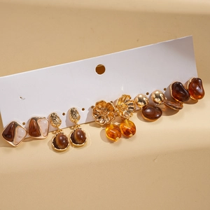 Detail view of a 6-pair earring set featuring gold-toned resin drops and floral designs