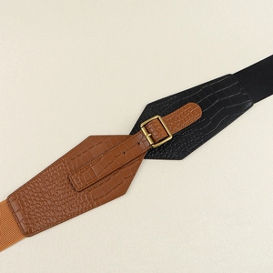 Detailed view of crocodile embossed leather belt with a golden square metal buckle