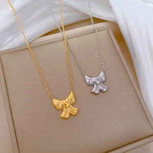 Minimalist bow knot necklaces in gold and silver steel finish on elegant white silk