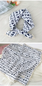 Detail of linen cotton scarf featuring black geometric patterns and delicate lace edges