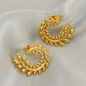Golden wheat ear C-shape earrings in vintage style on elegant grey satin fabric background
