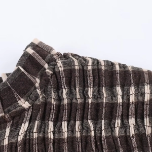 Close-up of brown honeycomb grid pattern and smocked texture on women shirt