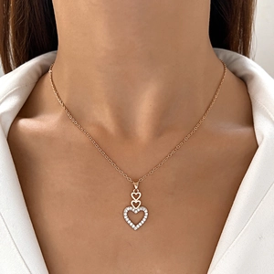 Detailed view of gold plated necklace with three stacked hearts and sparkling zircon stones