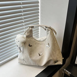 Minimalist beige textured tote bag with silver butterfly charms and cloud pendant