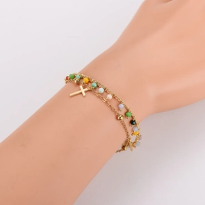 Bracelet double chaîne dorée avec perles colorées et deux pendentifs croix au poignet