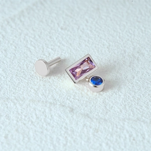 Close-up of s925 silver ear stud with purple rectangle and blue round gemstones