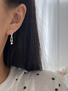 Close-up of S925 sterling silver horseshoe stud earrings with sphere charms on model