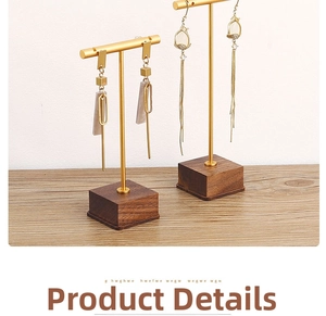 Detail of walnut wood base and gold metal T-bar jewelry stands for earring display