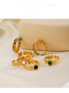 Detail of adjustable gold rings with turquoise and black onyx in a hammered wave design