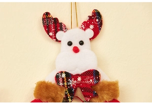 Close-up of white felt reindeer ornament with red tartan antlers and golden hanging string