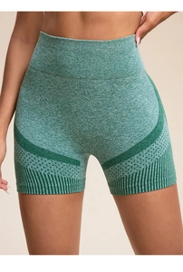 Detail of high-waist seamless yoga shorts showing green marl knit texture and laser cutouts