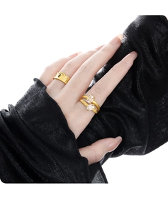 Close-up of golden hollow double-layer rings with rectangle rhinestones and hammered texture