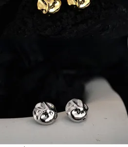 Detailed view of irregular lava-style S925 silver stud earrings in gold and silver finishes
