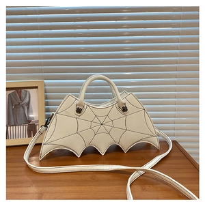 Detail of white bat wing bag with black spider web stitching and crossbody strap
