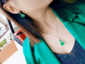 Detail shot of a model wearing a green chalcedony jewelry set with diamond accents