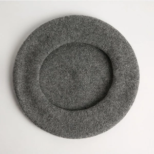 Minimalist medium grey wool beret hat for women shown from a top-down view on white background
