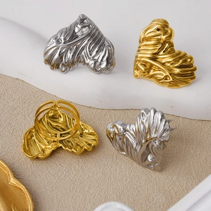 Detail shot of heart-shaped gold and silver rings with irregular lava texture finish