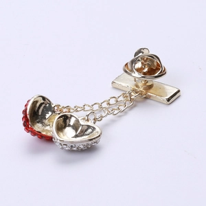 Detail of dual-tone heart brooches with gold and silver finishes on white background