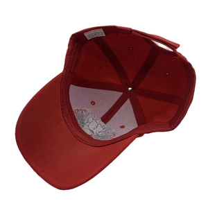 Detailed view of the red baseball cap interior stitching and 100% acrylic material tag