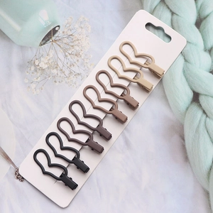 Set of six matte brown duckbill hair clips neatly arranged on a white card display