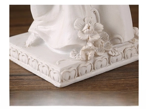 Detail of European angel candle holder base with floral reliefs and thick resin construction