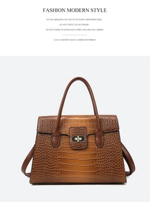 Close-up of brown crocodile texture leather and golden twist lock on a luxury handbag