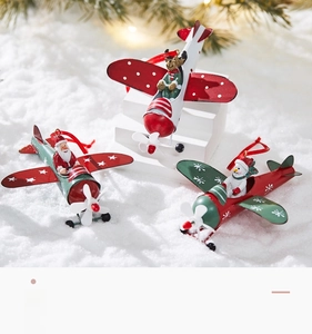 Detailed view of three painted metal airplane ornaments with Santa, Snowman and Reindeer