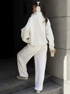 Street style view of a grey oversized zip-up hoodie and wide-leg sweatpants set